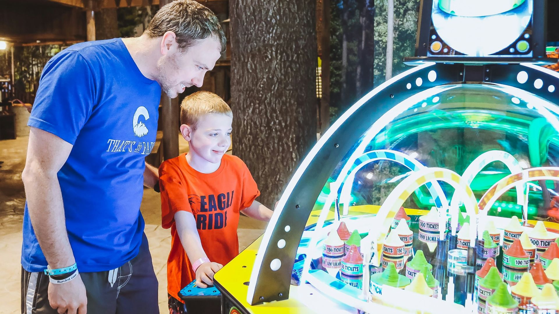 a man and a boy playing a game of pinball