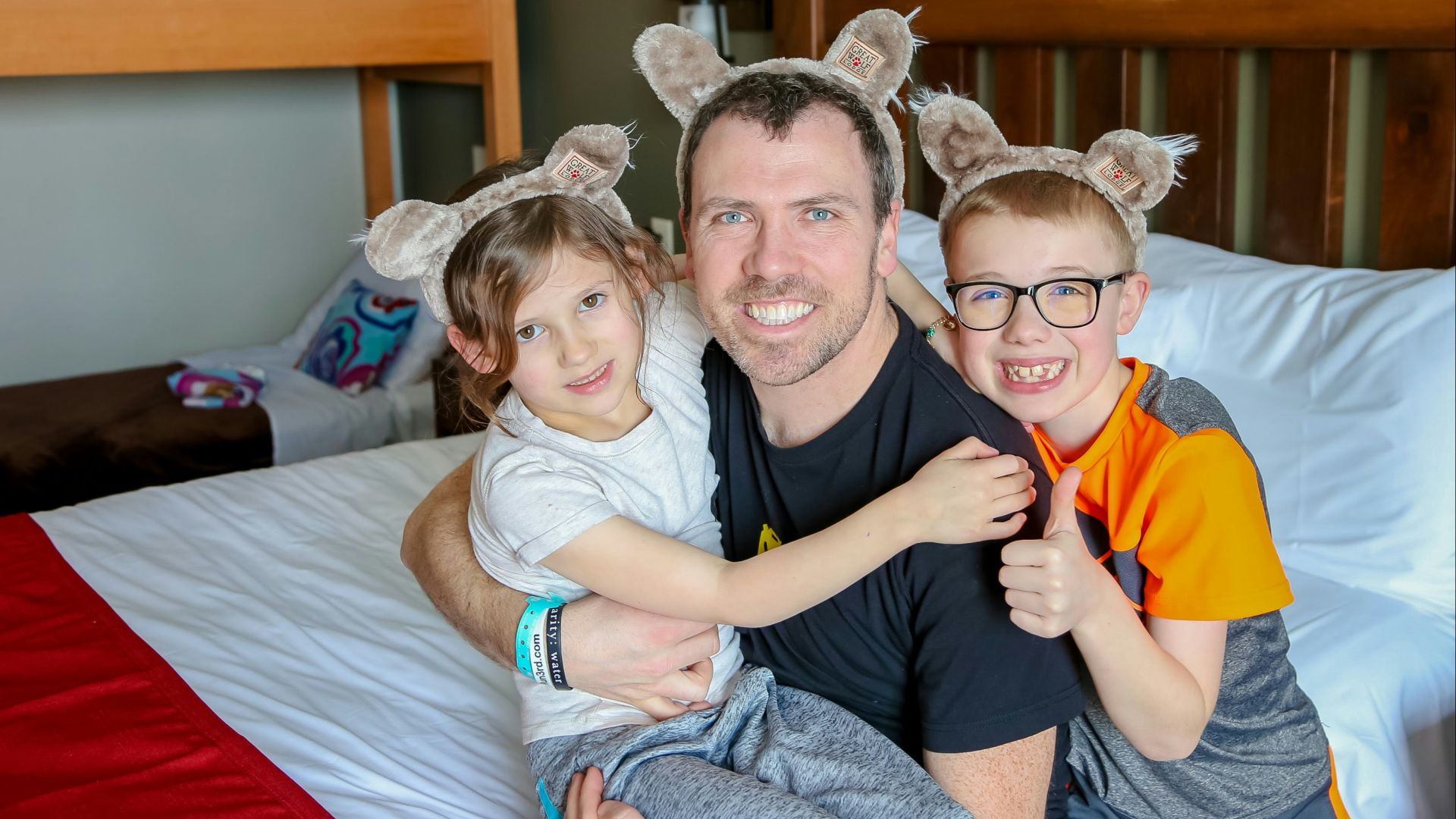 a man and two children sitting on a bed