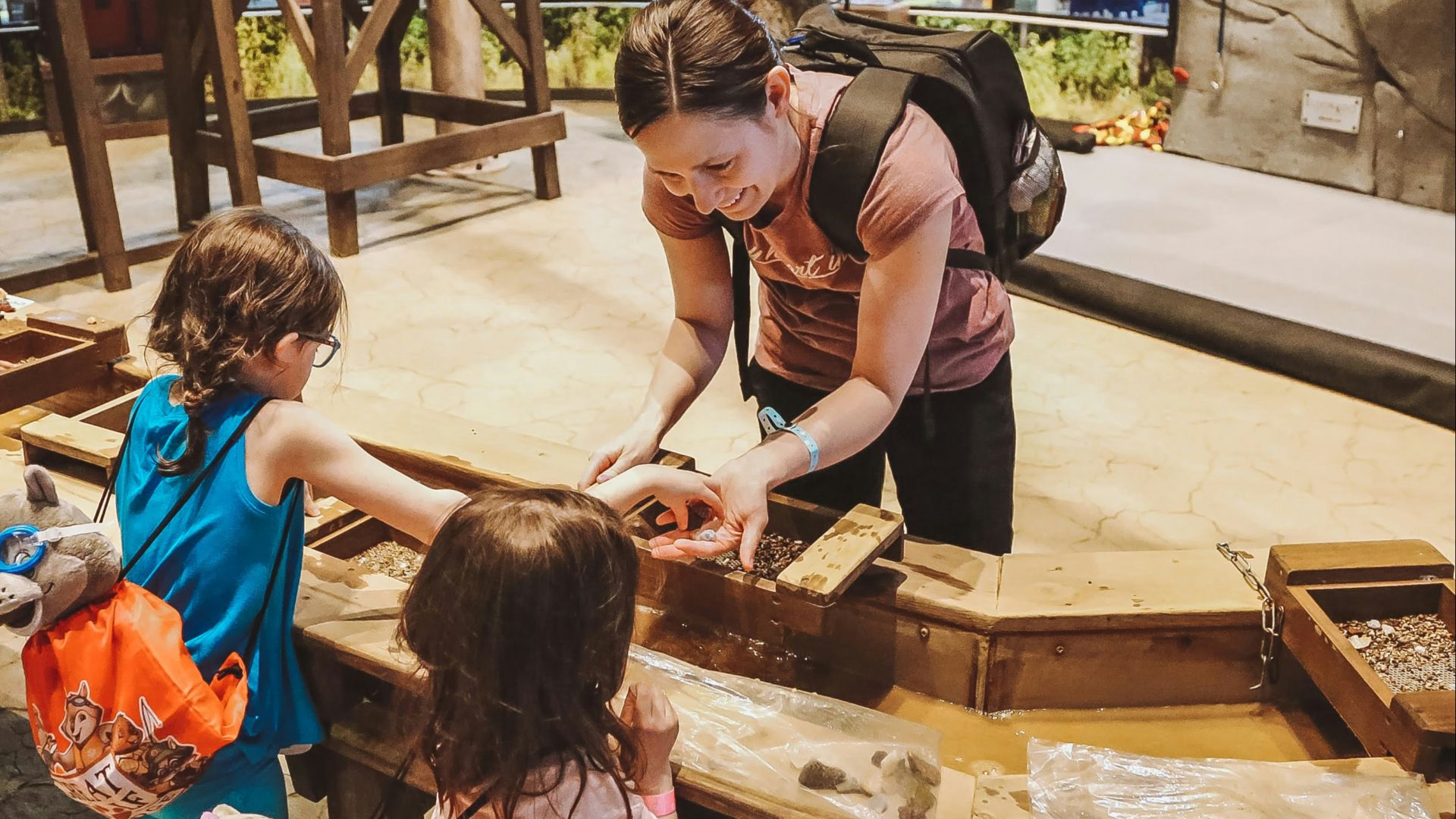a woman and two little girls looking at a box