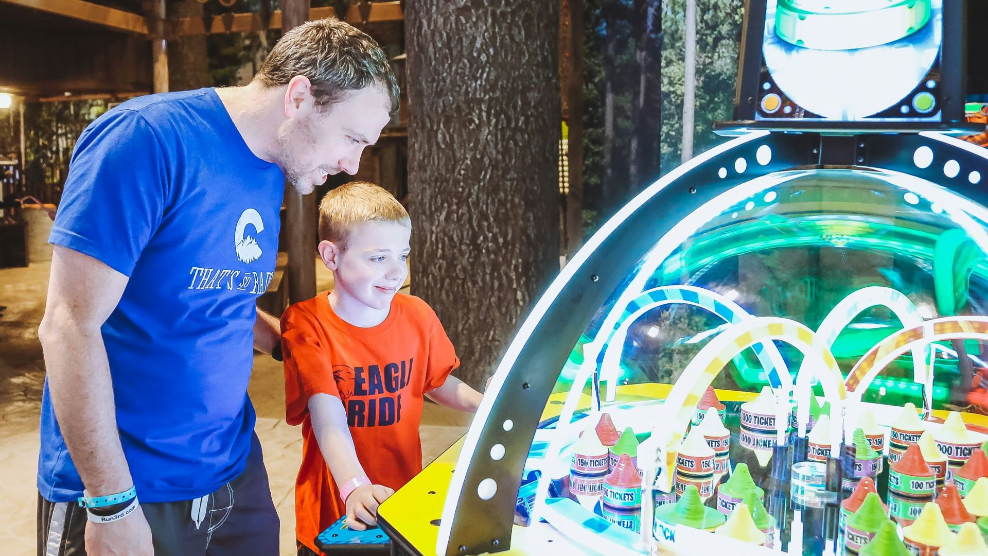 a man and a boy playing a game of pinball
