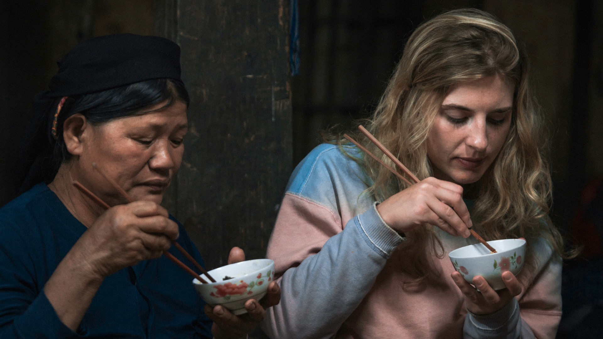 two women using chopsticks for eating