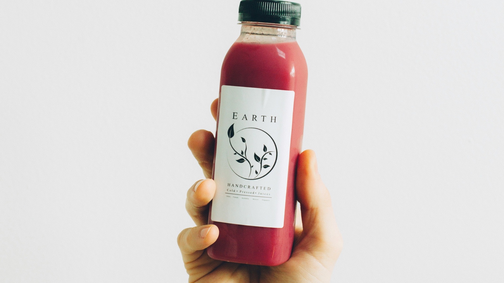 person holding Earth labeled bottle