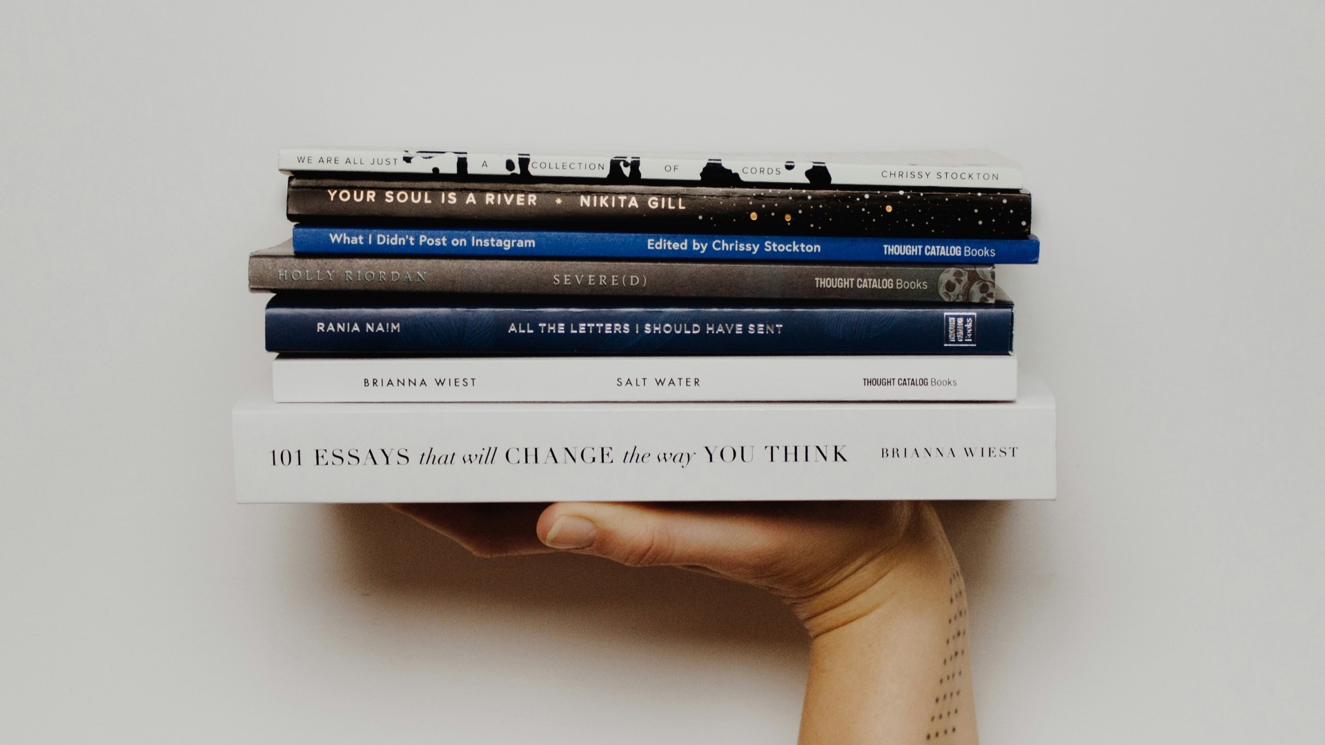 person holding pile of books
