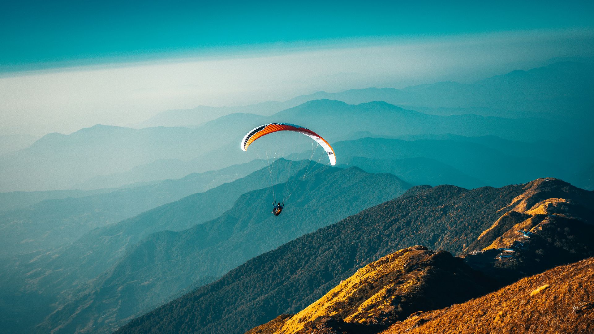 person in parachute over mountains during daytime