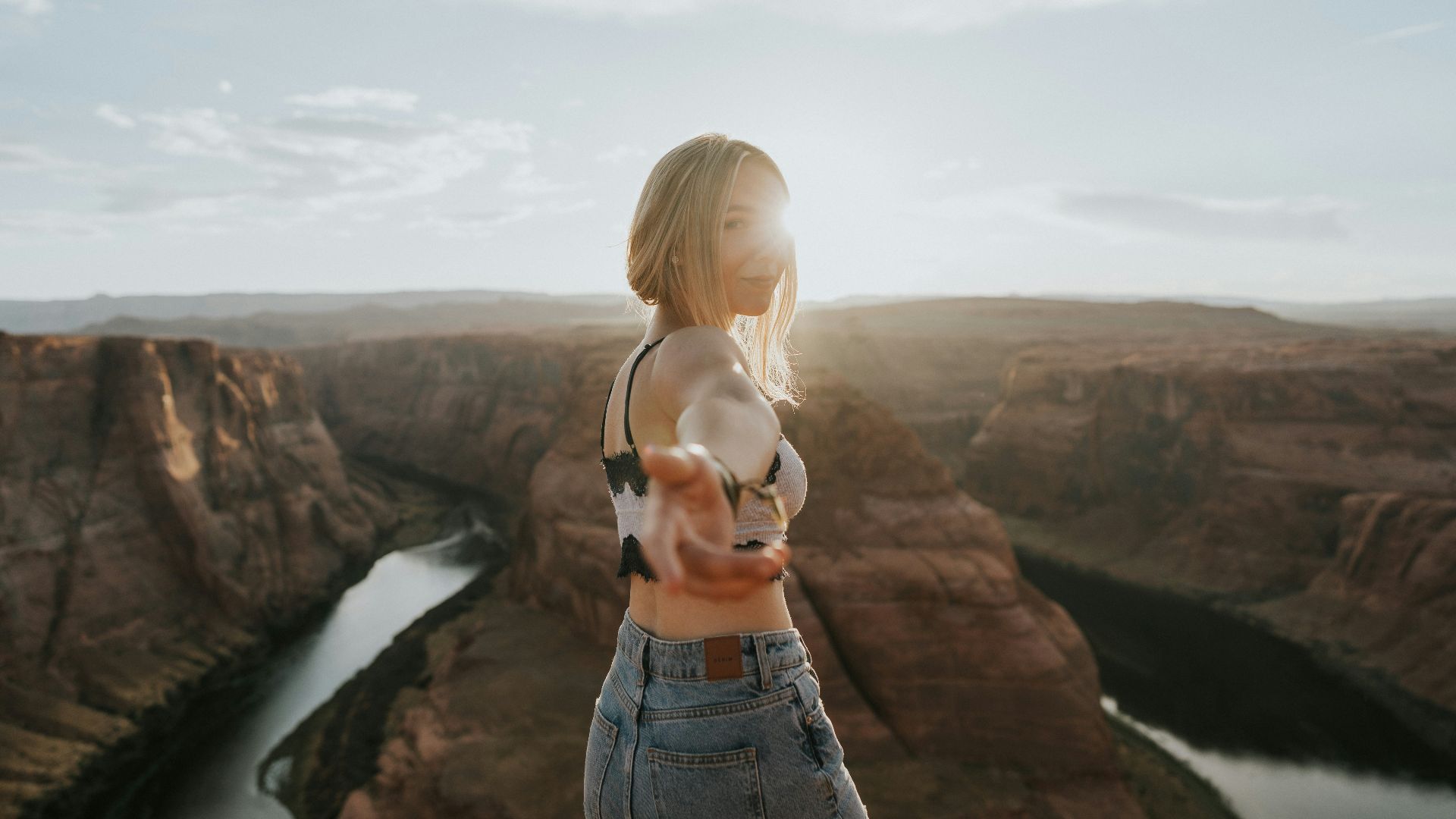 woman in blue denim shorts standing on cliff during daytime