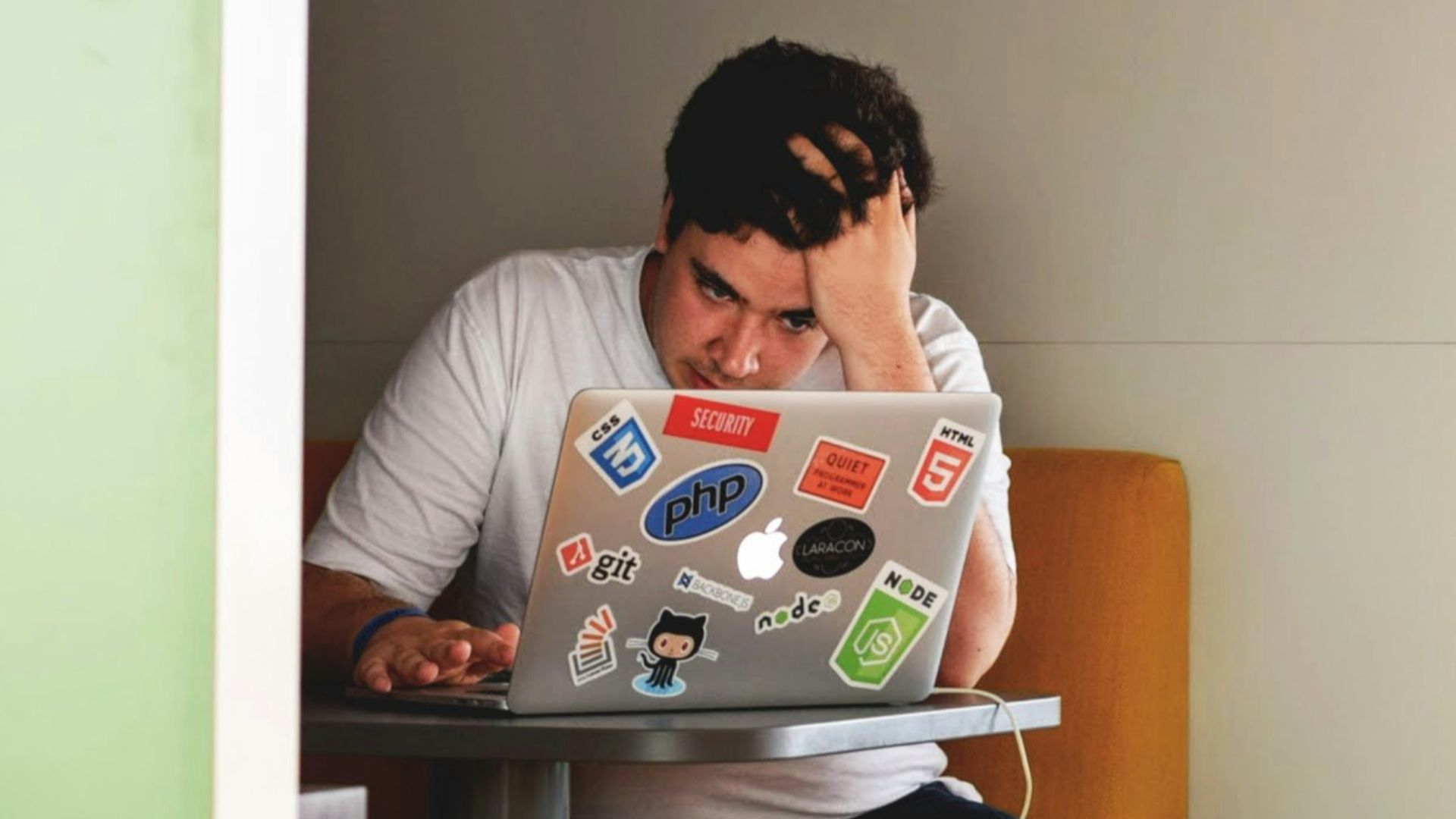 man wearing white top using MacBook