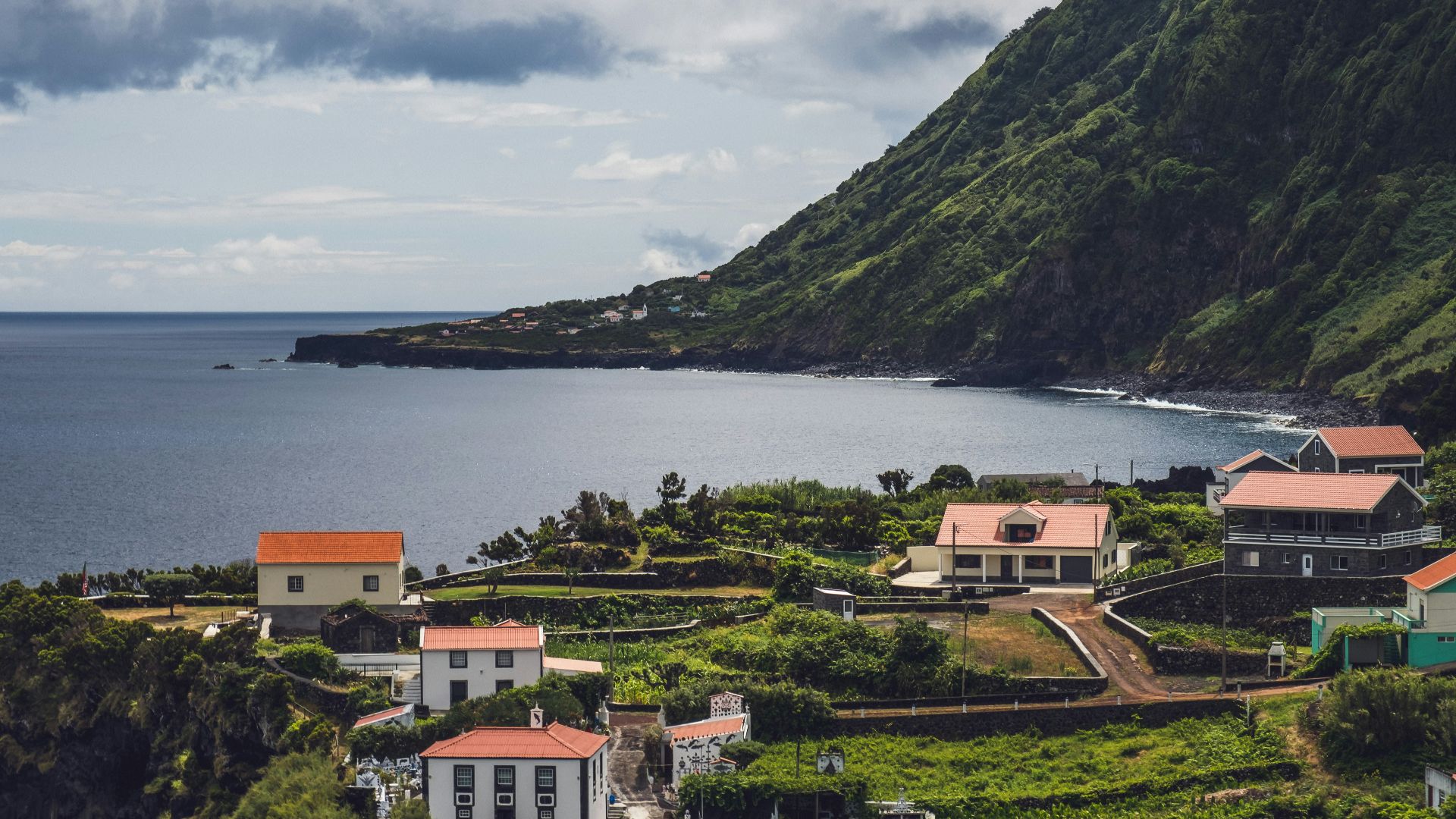 white and brown concrete houses near body of water during daytime