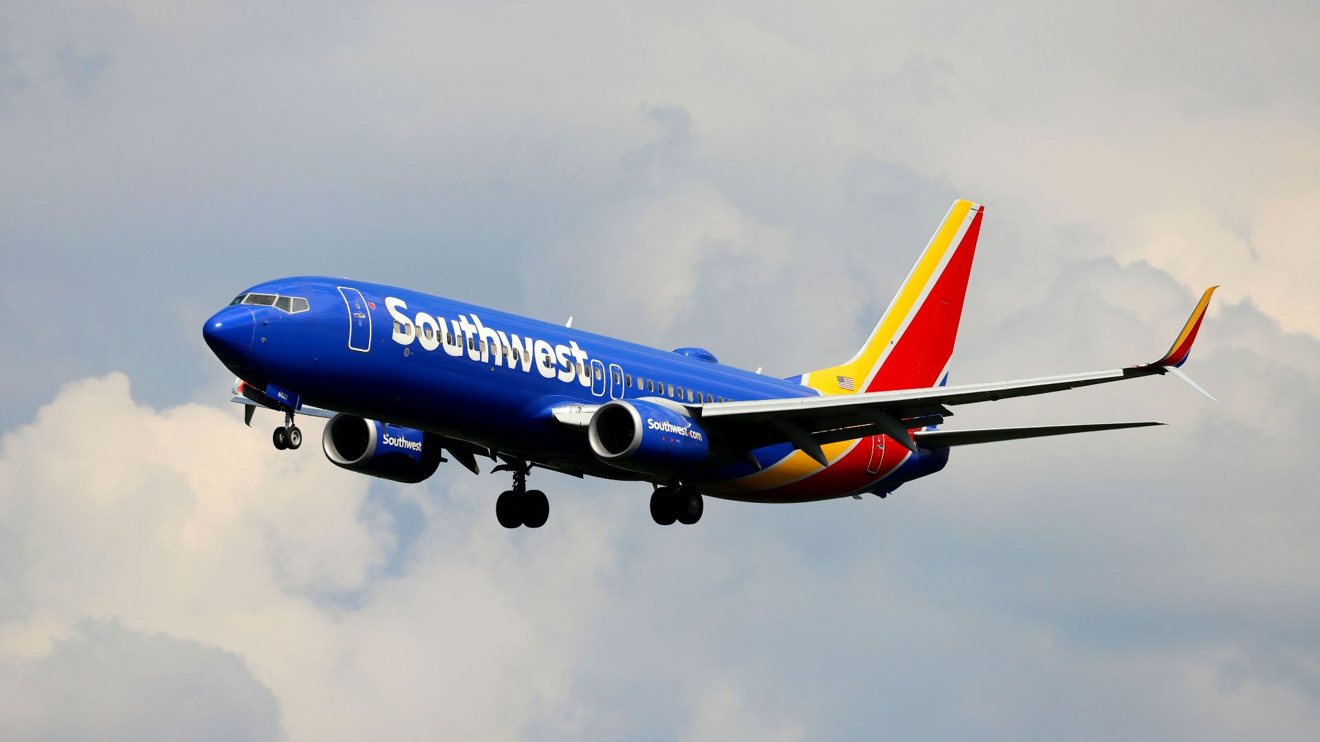 a blue and white airplane flying in the sky