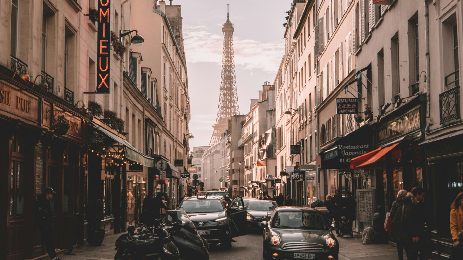 vehicles travelling on road surrounded by buildings during daytime