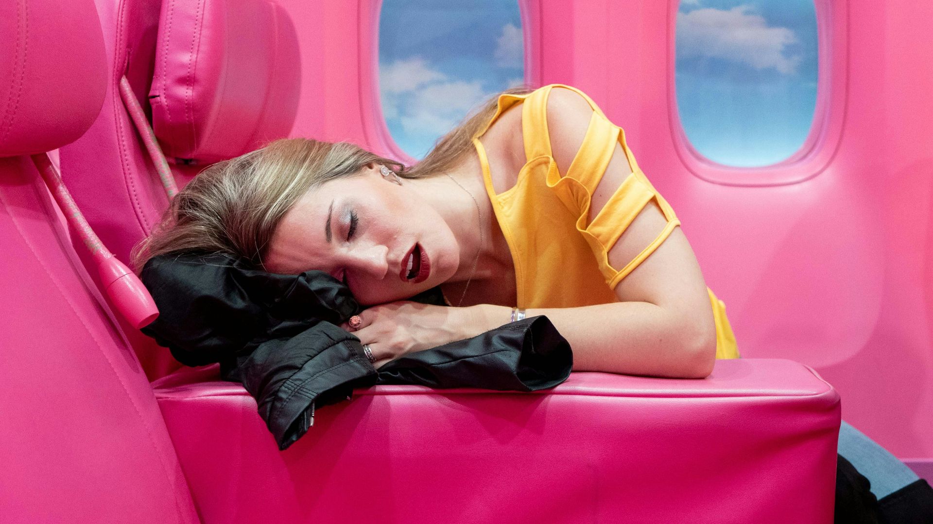 girl in yellow long sleeve shirt lying on red inflatable bed