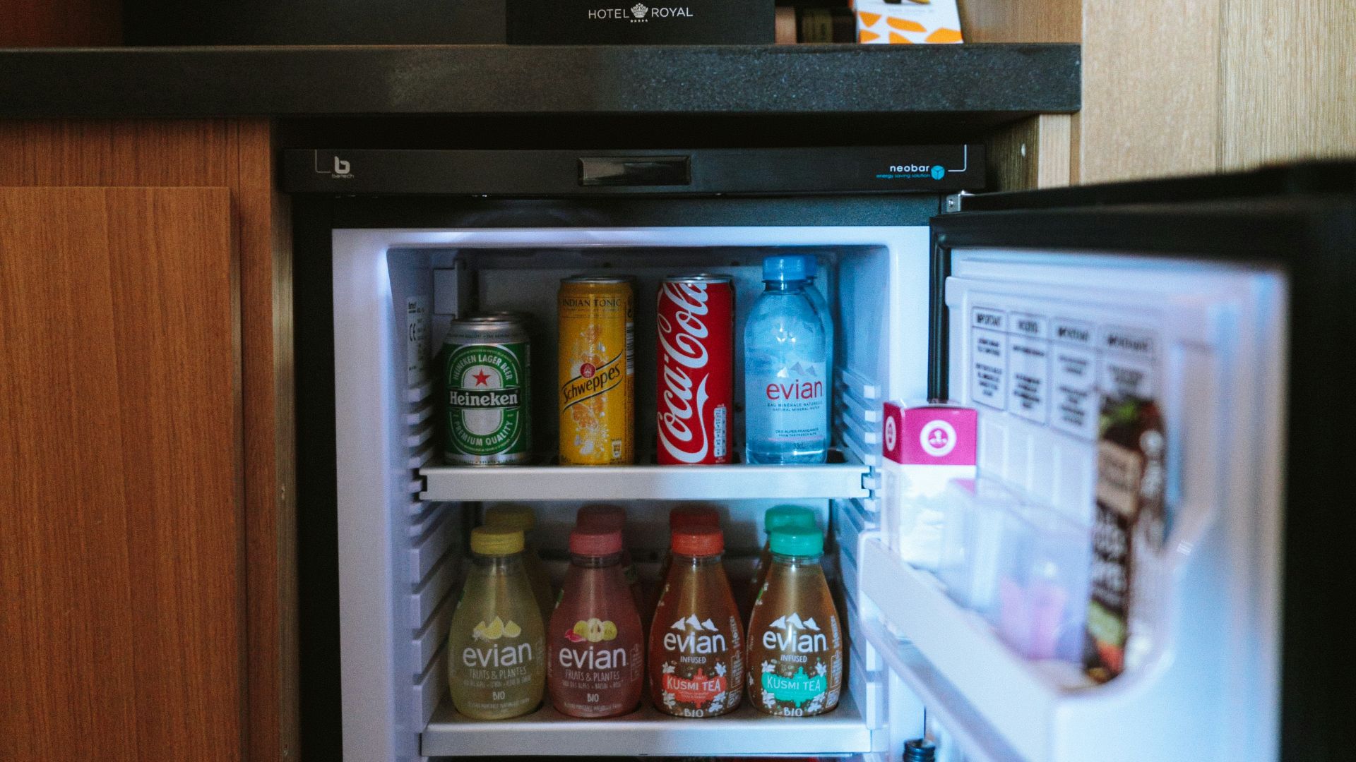 open black compact refrigerator filled with soda bottles