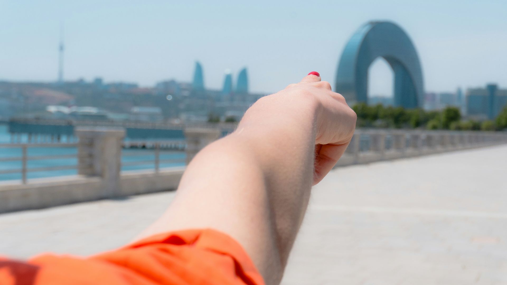 Hand pointing towards a modern city skyline