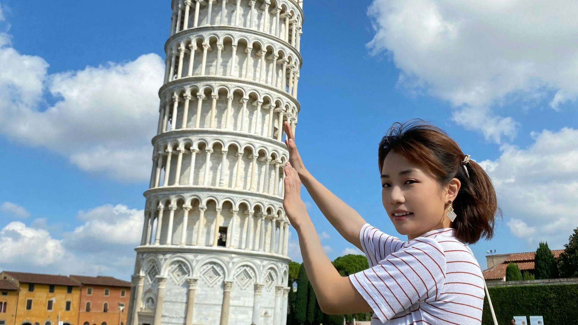 a woman standing in front of the leaning tower of pisa