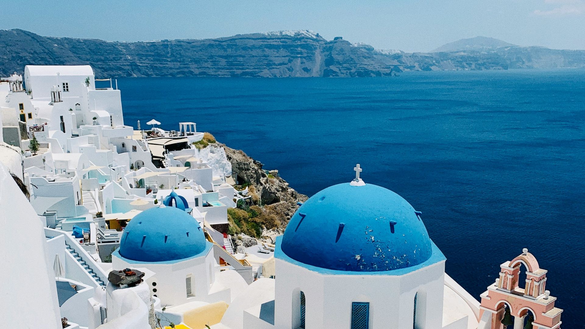 a view of a blue domed building on the edge of a cliff