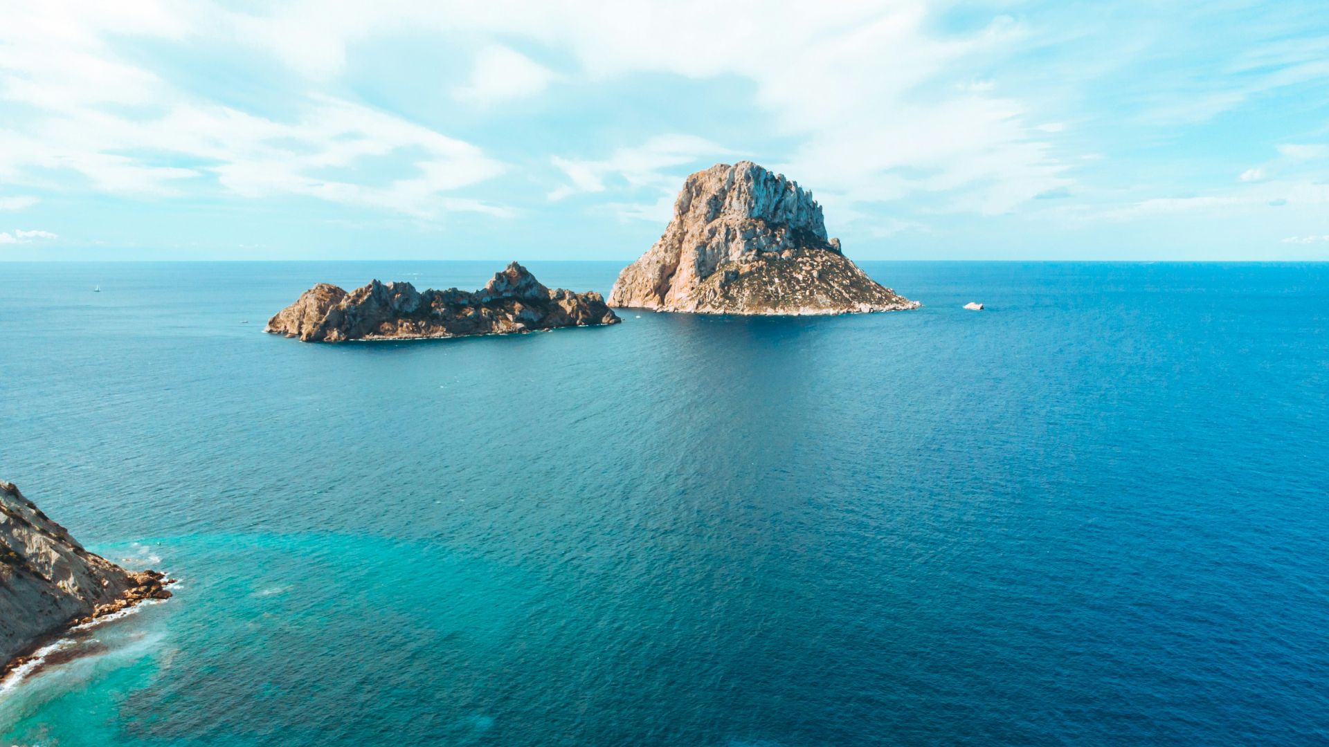 gray and brown rock formation on blue sea under blue sky during daytime