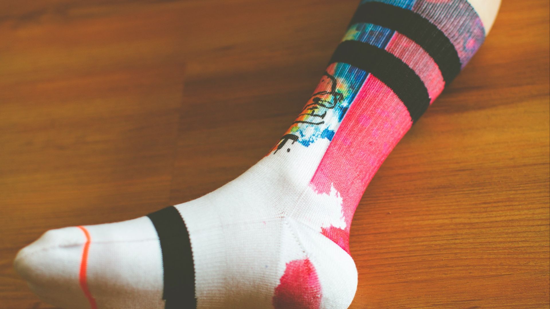 person wearing white green and pink sock