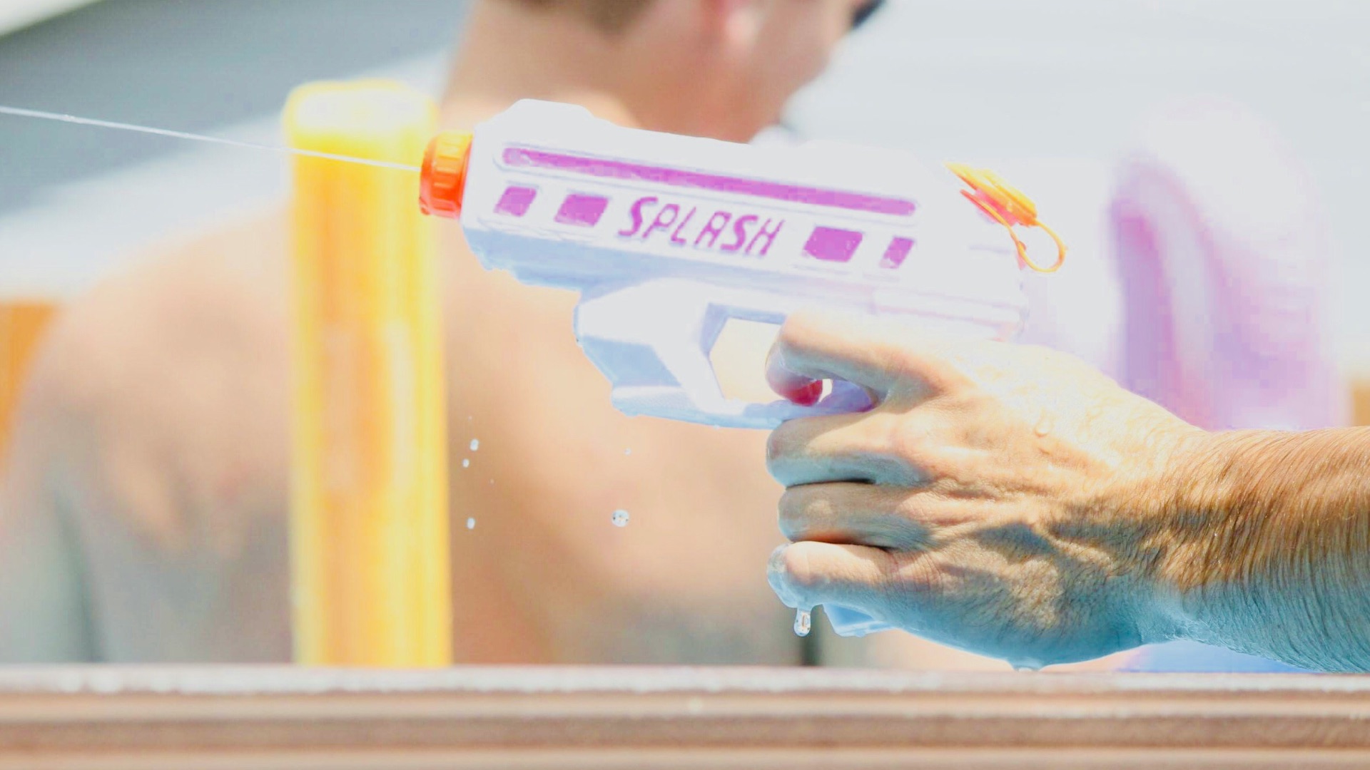 person holding pink and white Splash water gun