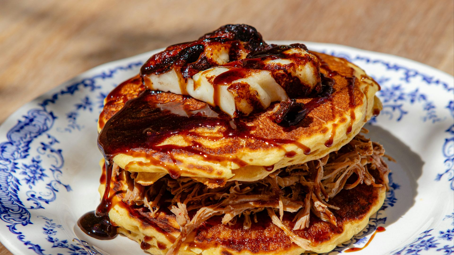 A stack of pancakes sitting on top of a blue and white plate