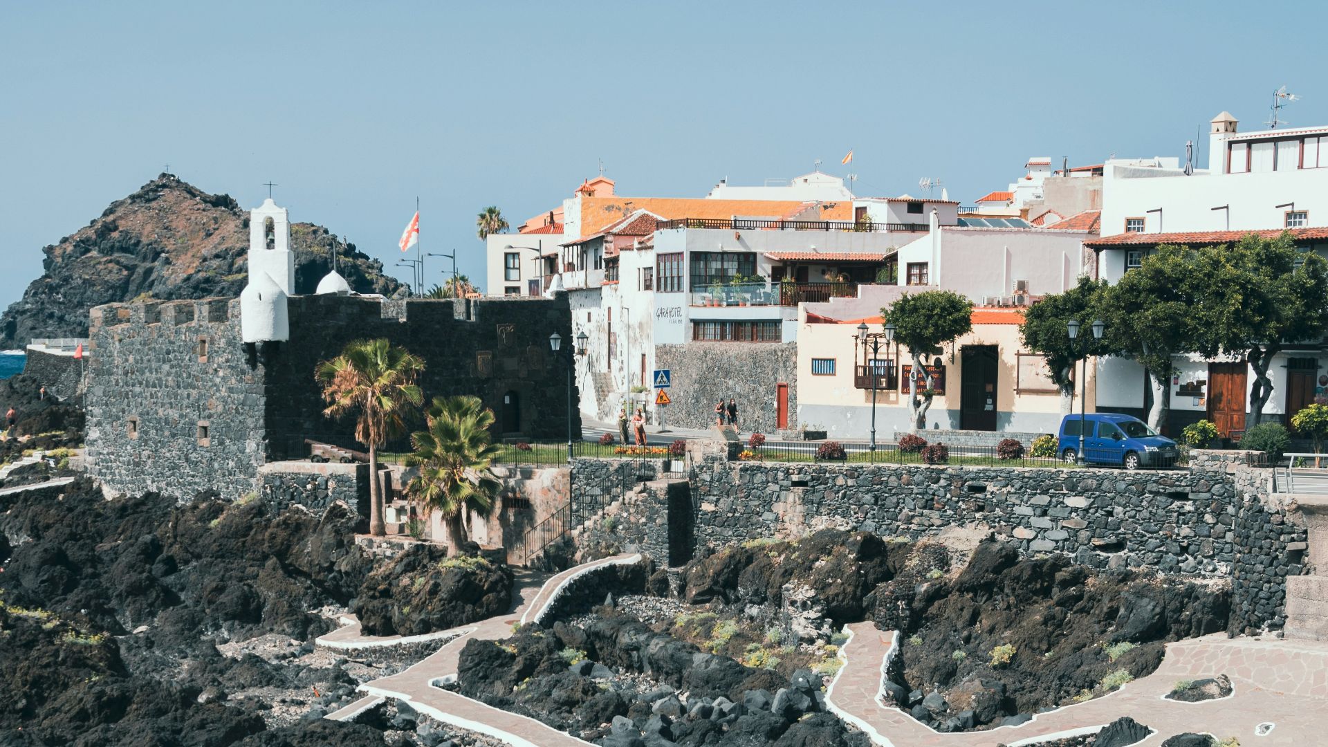 a view of a rocky beach with houses in the background