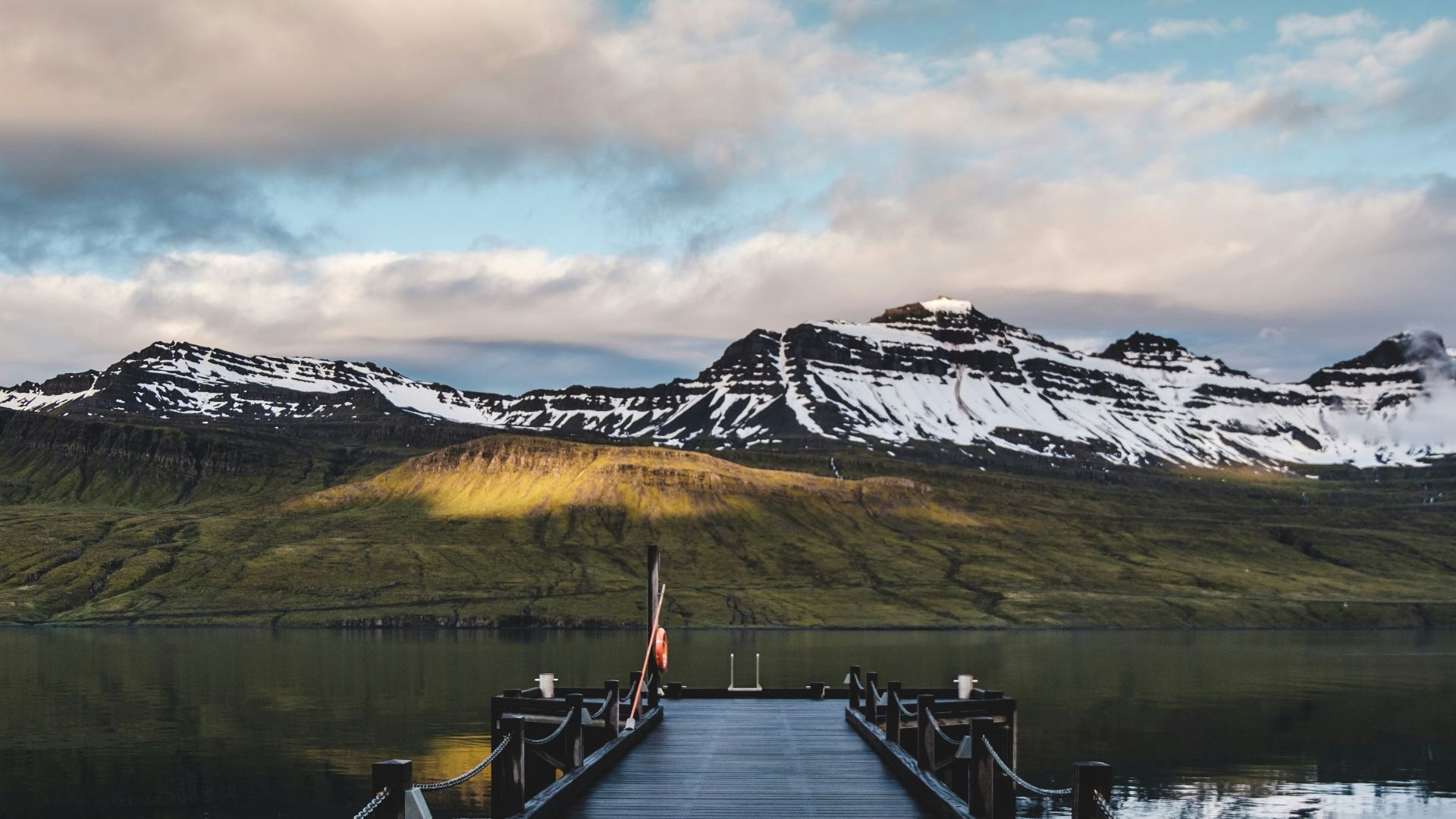 a wooden dock with mountains in the background