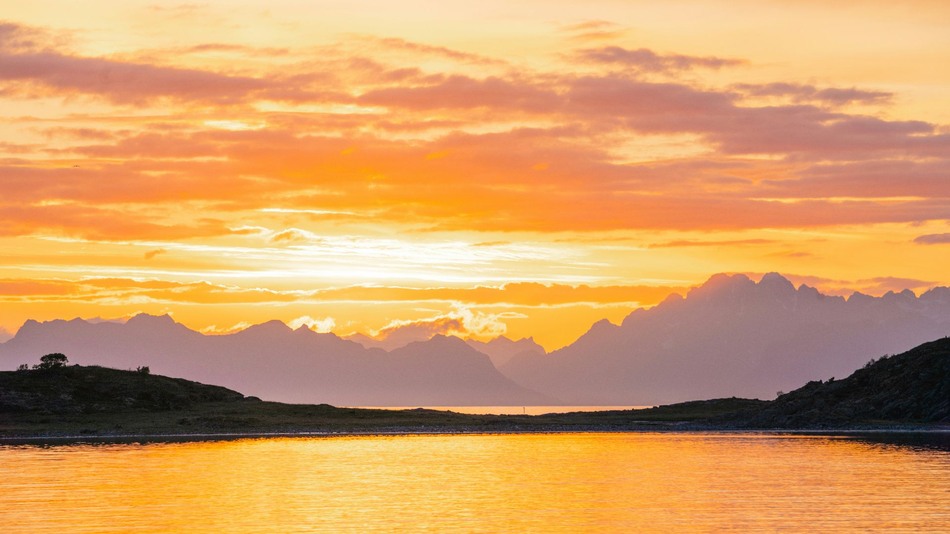 a body of water with mountains in the background