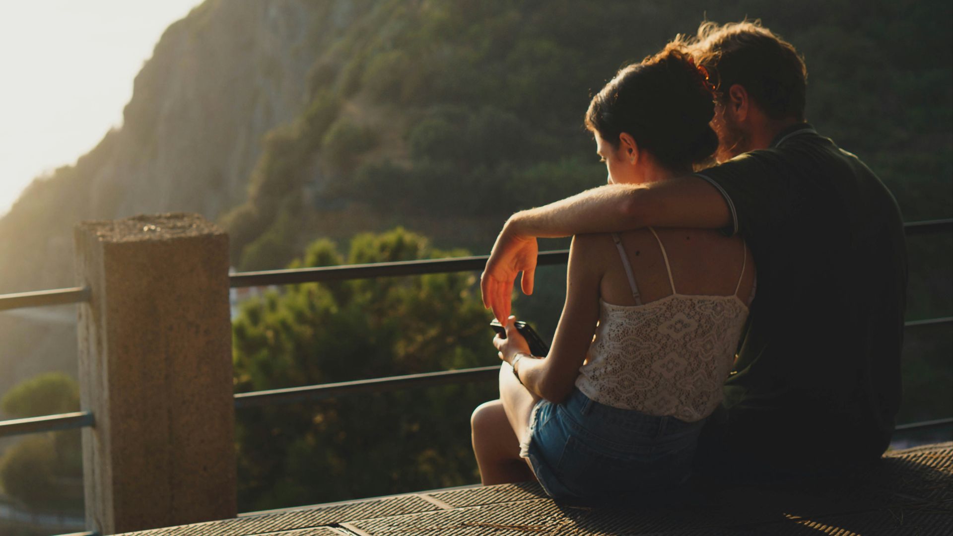 man and woman sitting on concrete surface