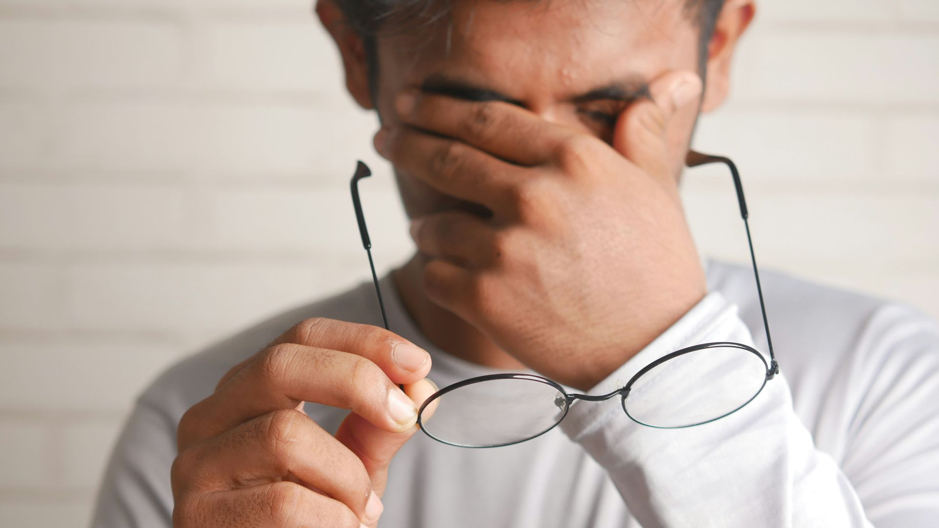 a man holding a pair of glasses up to his face