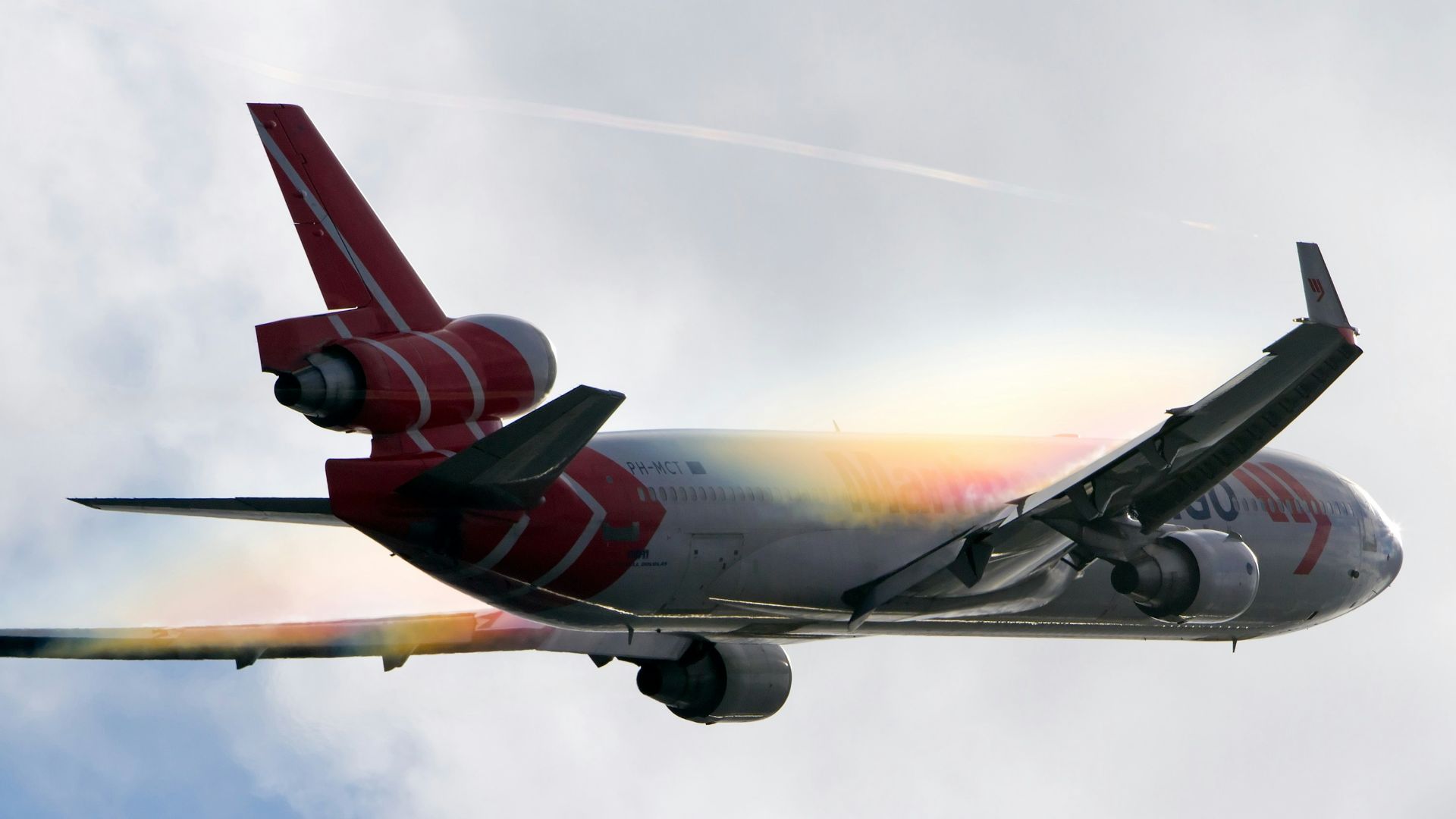 white and red airplane under white clouds during daytime