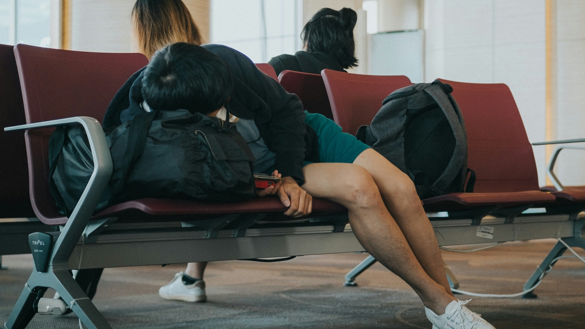 unknown person lying on brown bench indoors