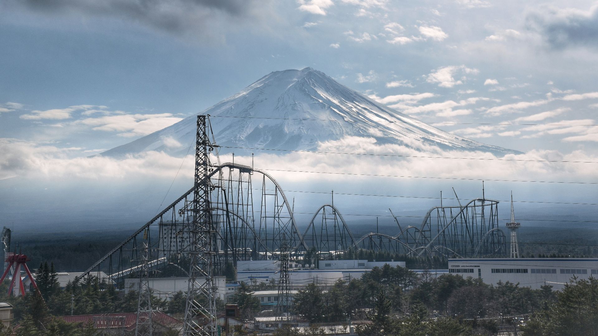 a roller coaster with a mountain in the background