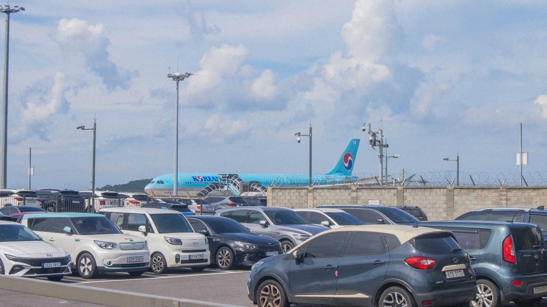 Cars parked with airplane in background