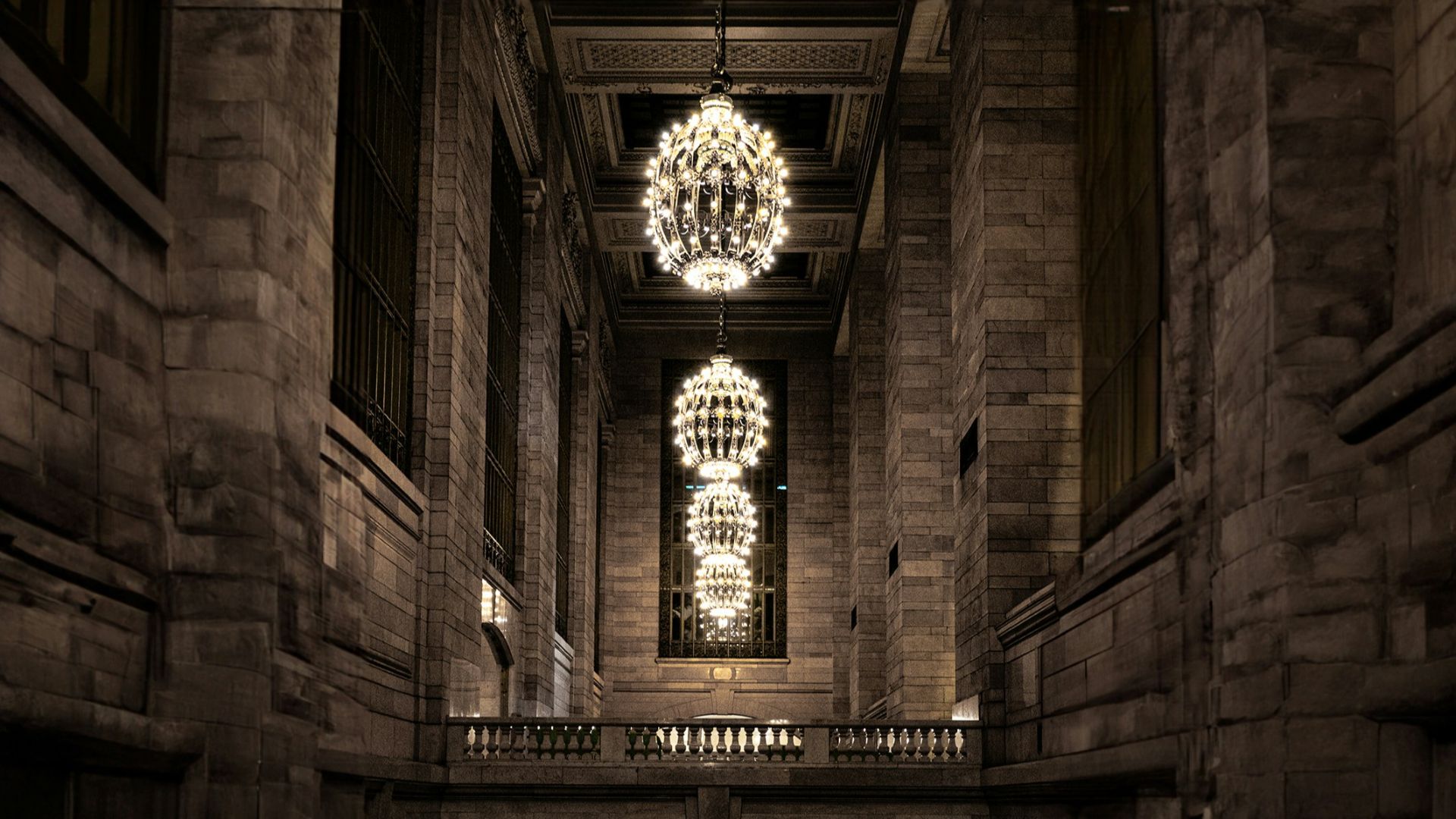 a dark hallway with a chandelier hanging from the ceiling