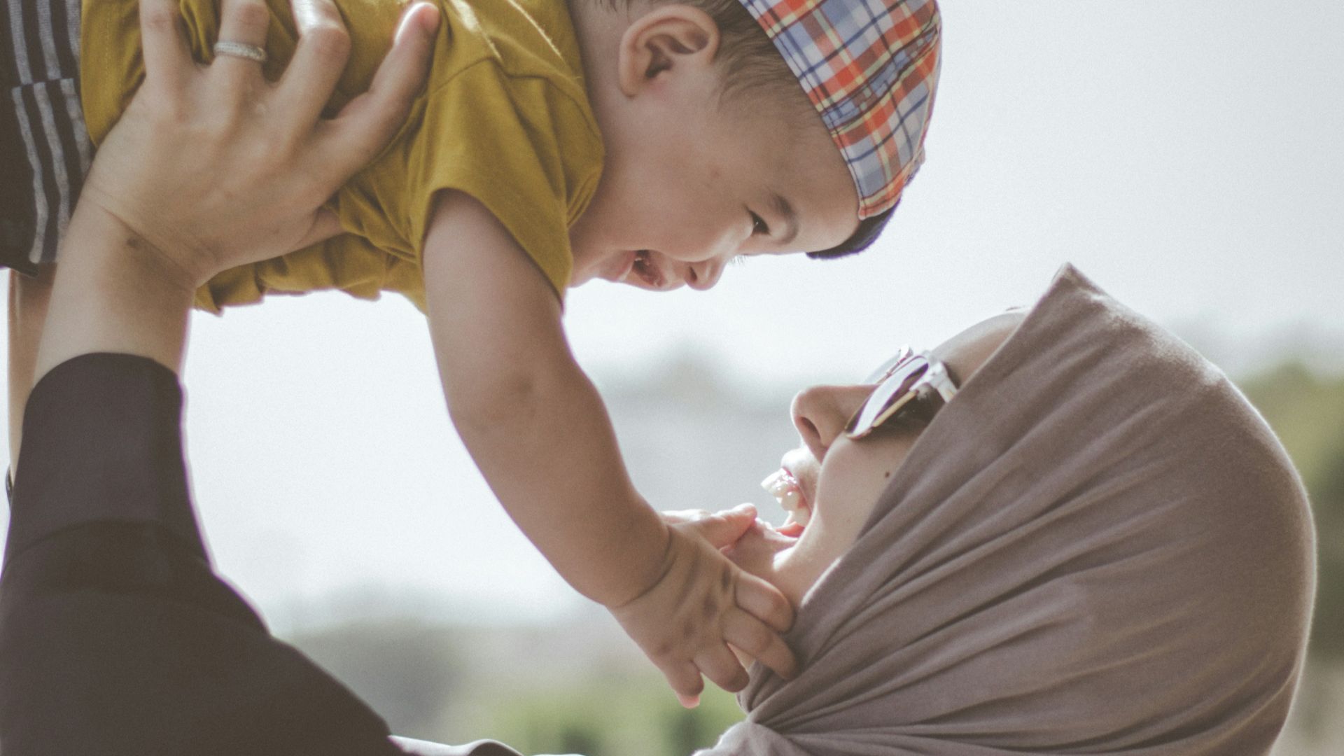 woman holding boy during daytime