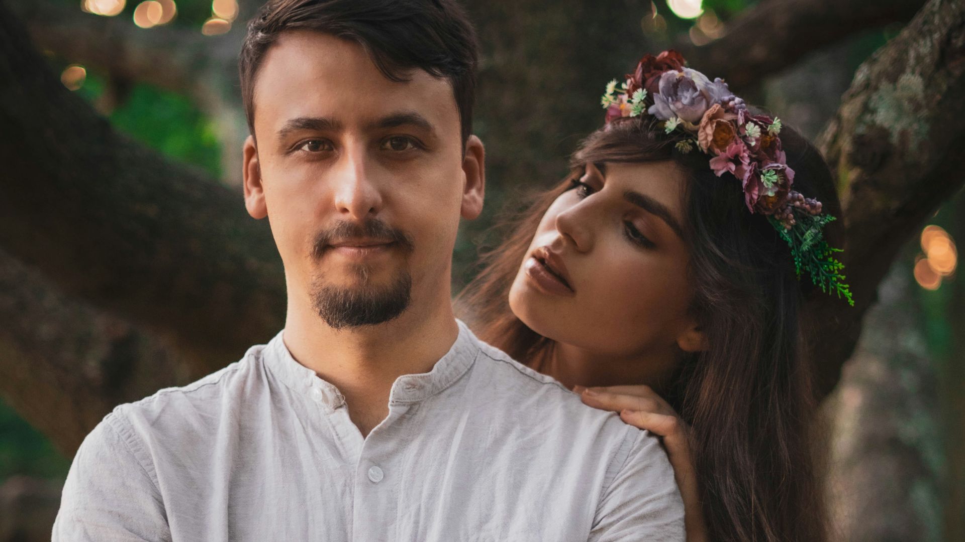 man in white polo shirt hugging woman in black dress