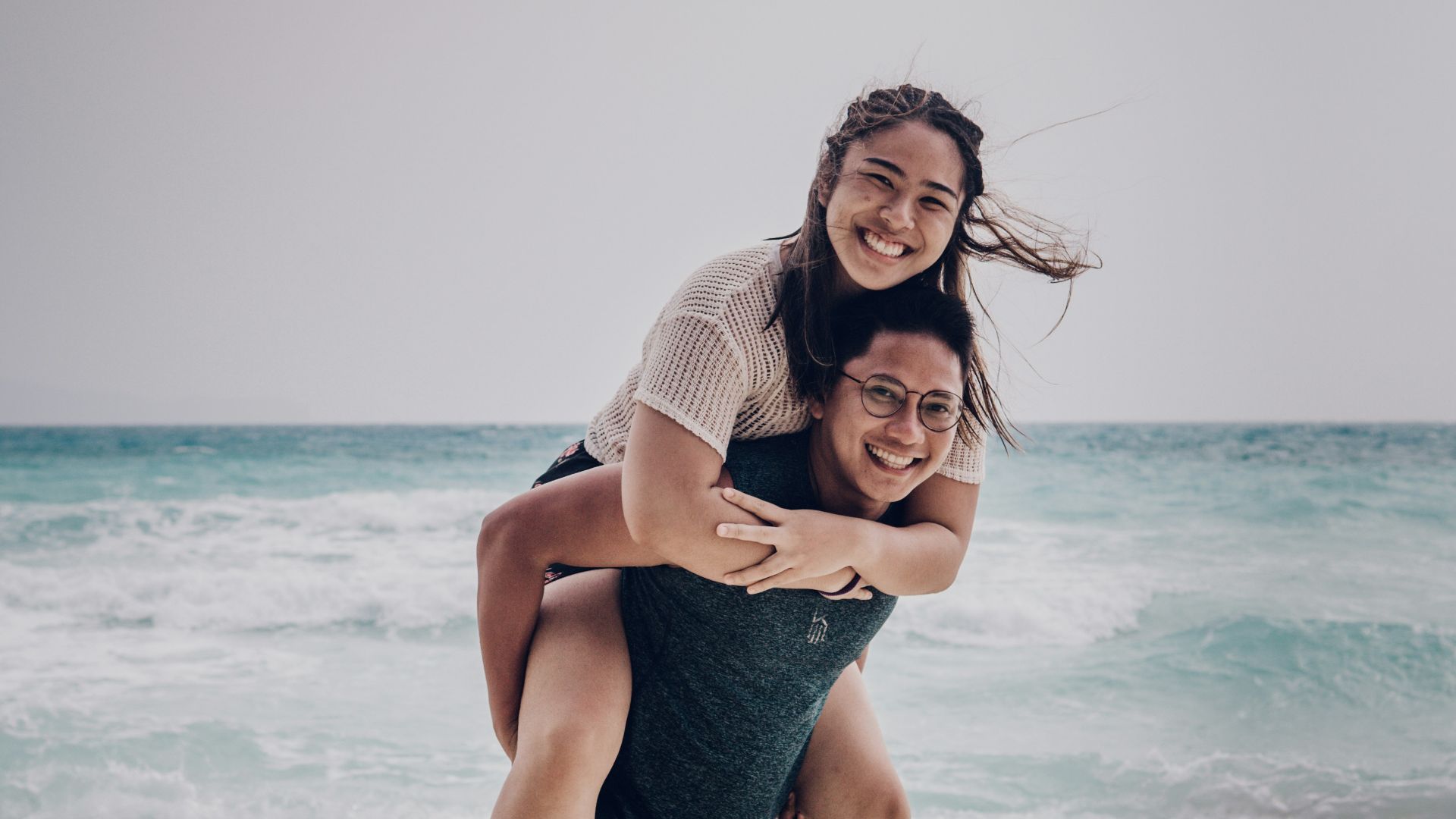 woman in blue denim shorts standing on beach during daytime