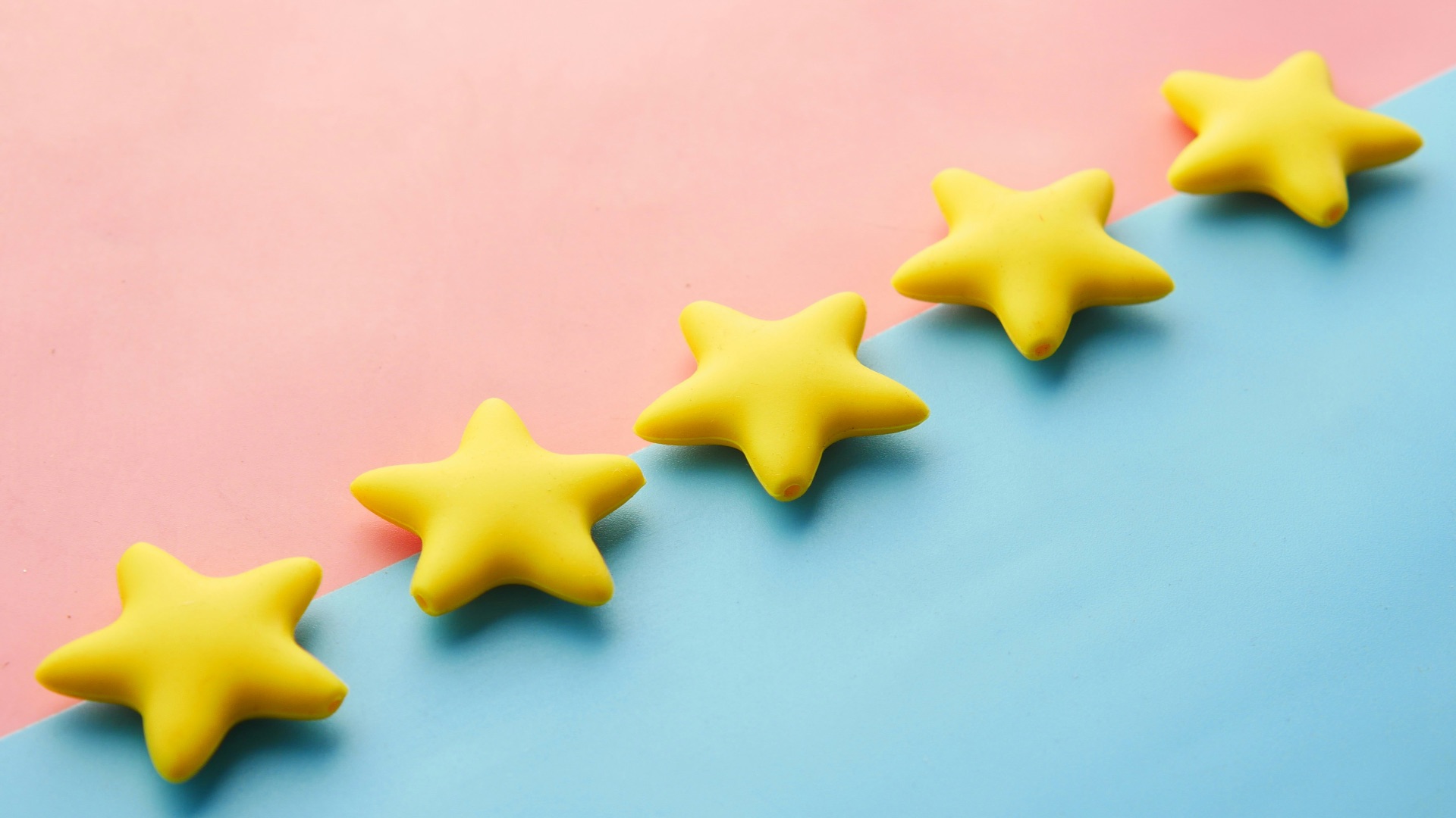 a row of yellow stars sitting on top of a blue and pink surface