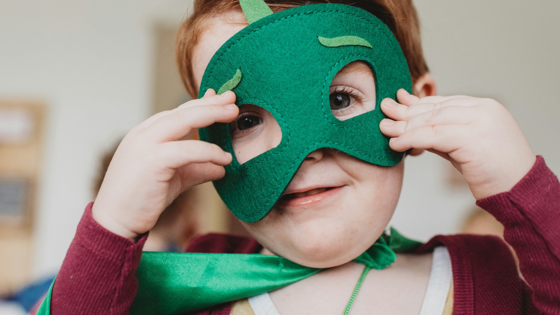 boy holding green mask
