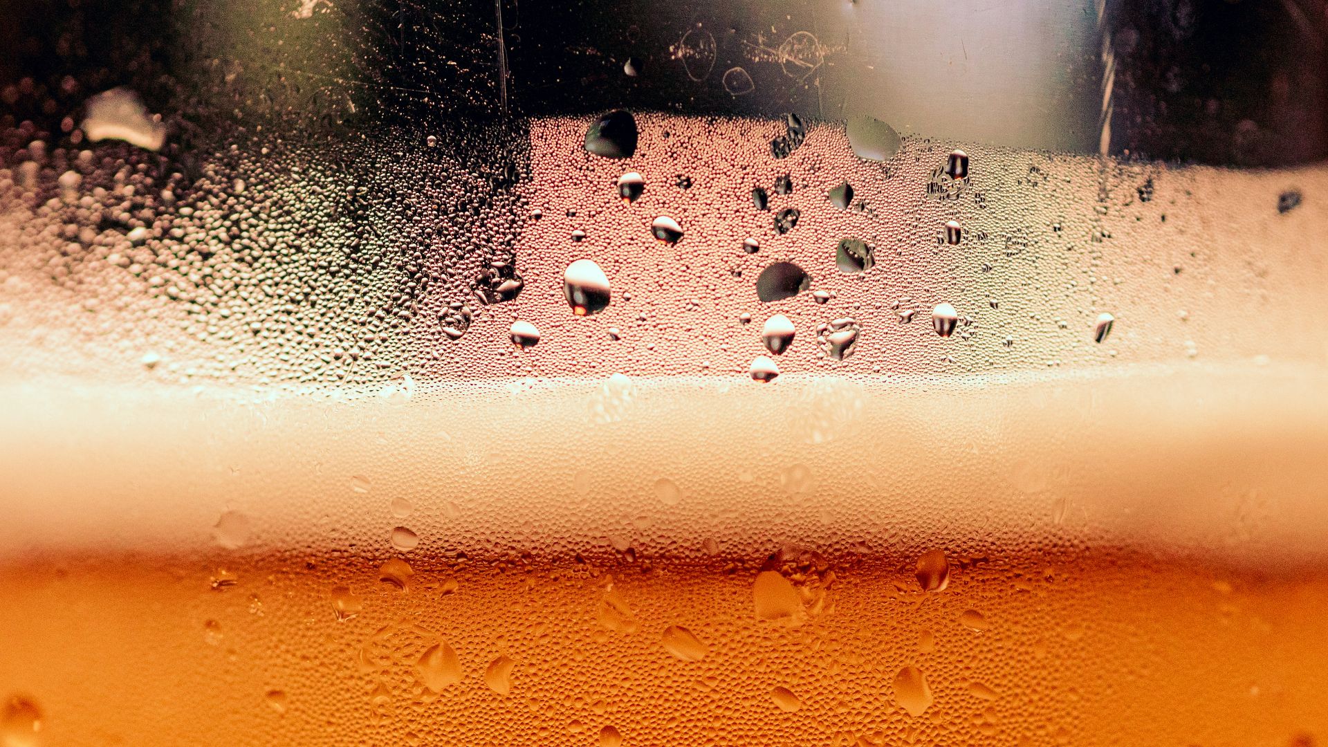 a close up of a glass of beer with drops of water