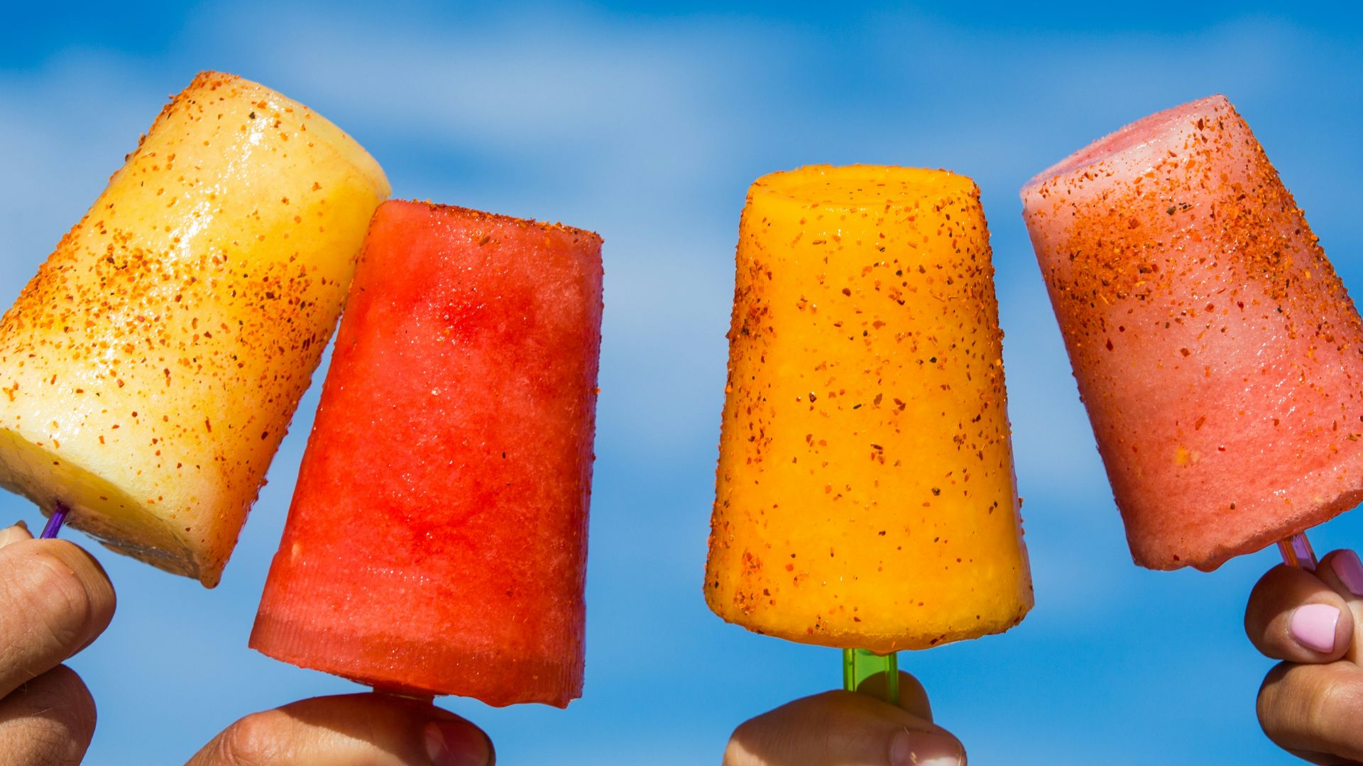 person holding orange ice pop