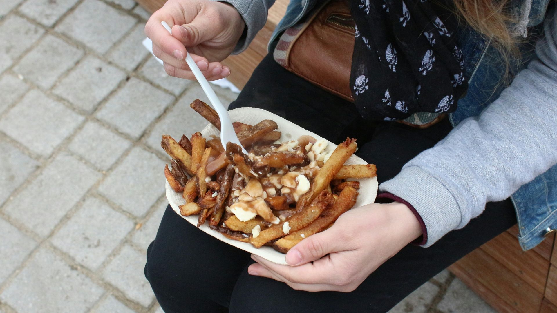 person holding burger with fries