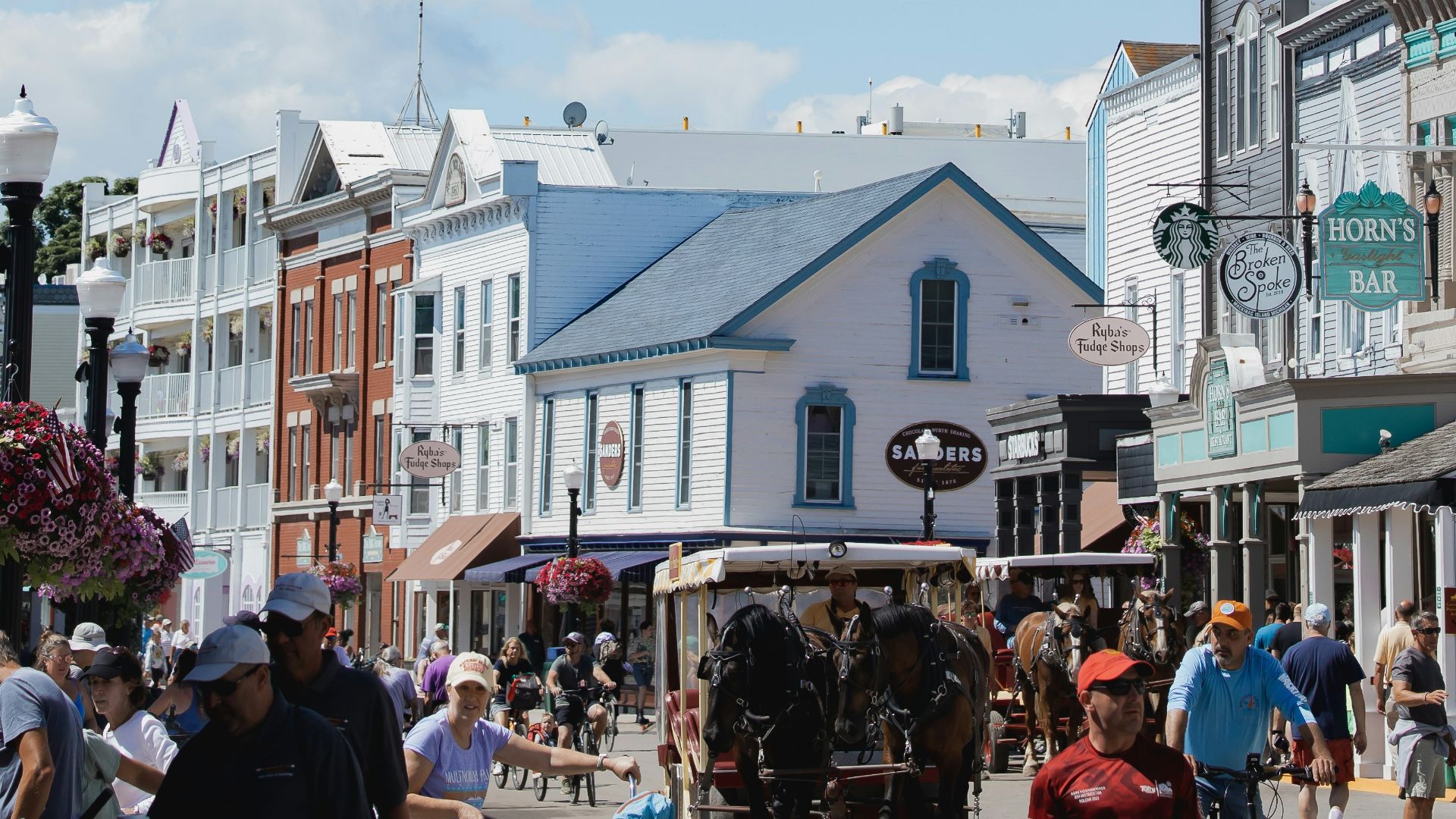 a group of people walking on a street with buildings and a flag