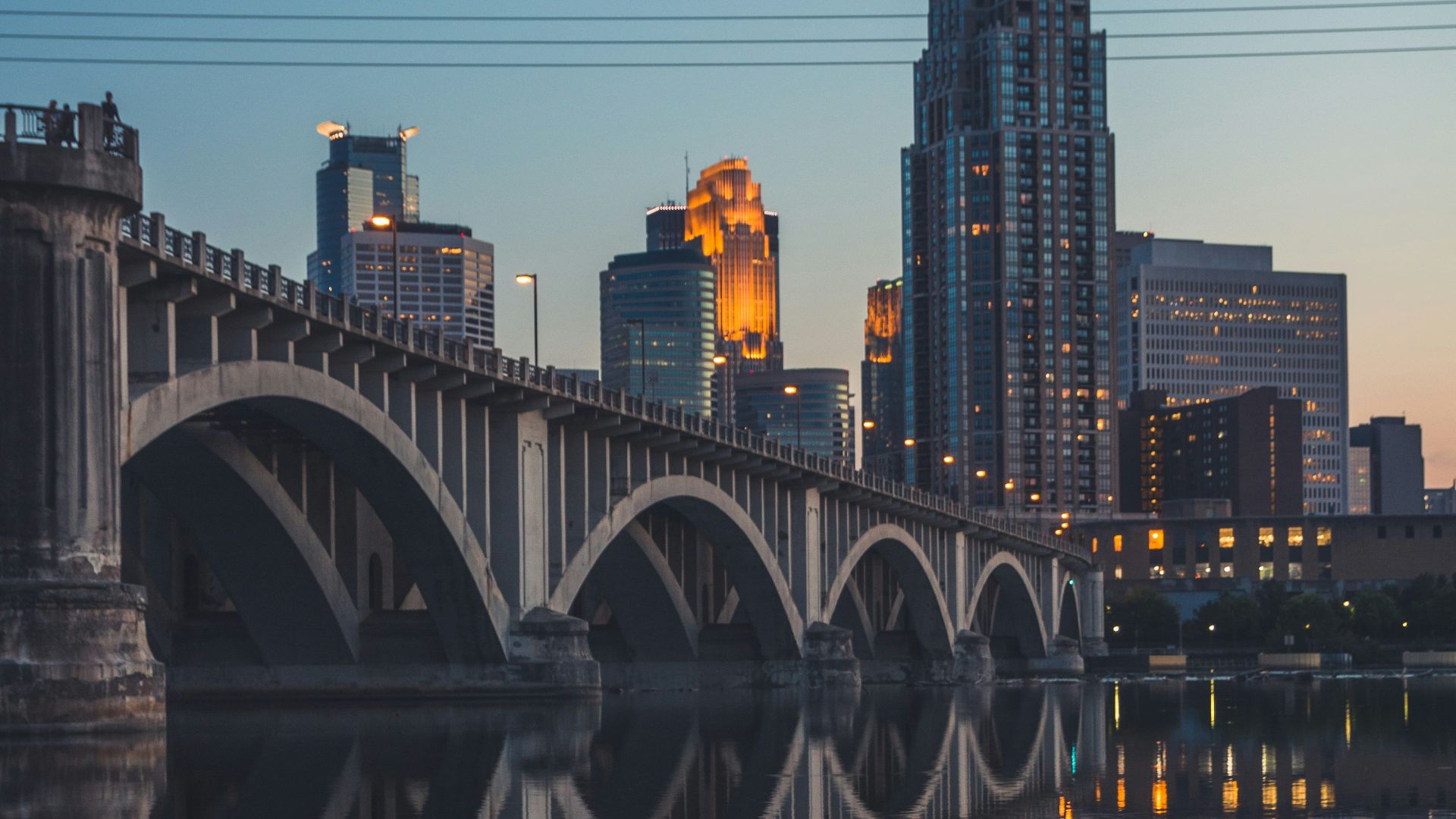 gray concrete bridge over body of water during night time