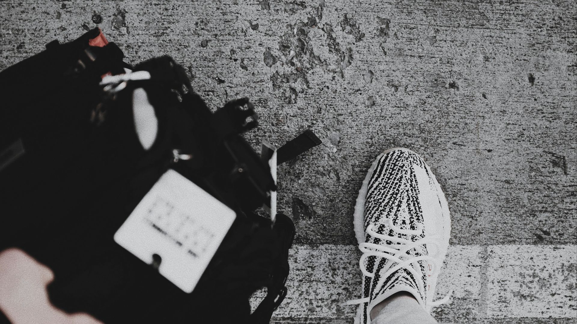 person wearing black and white adidas sneakers