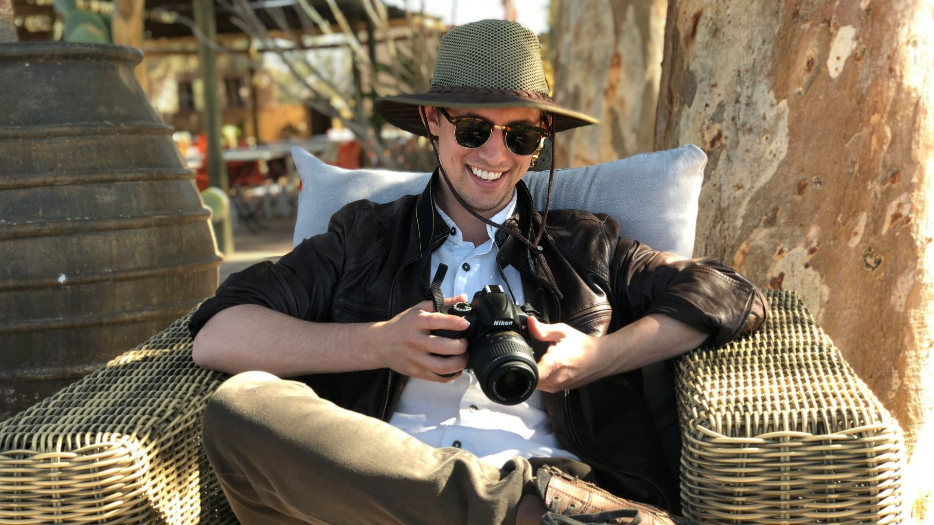 man sitting on chair while holding camera
