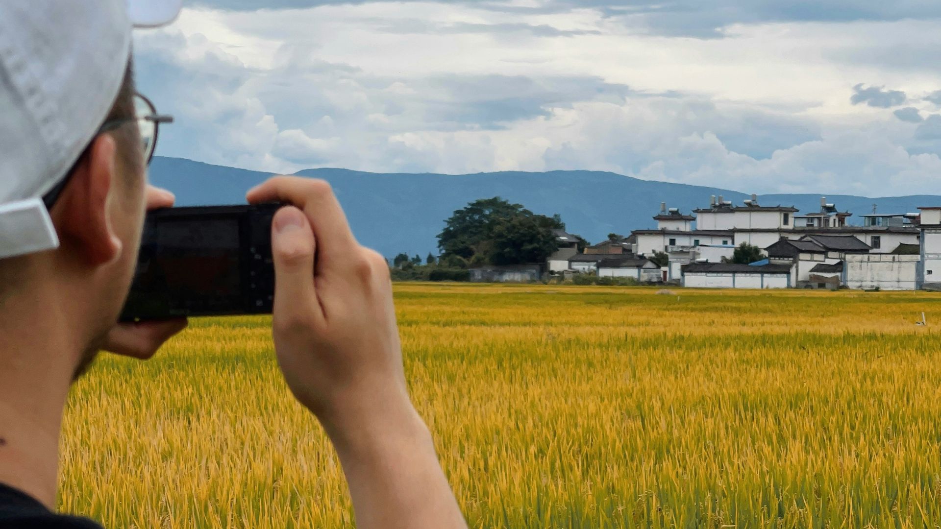 a man taking a picture of a field with a cell phone