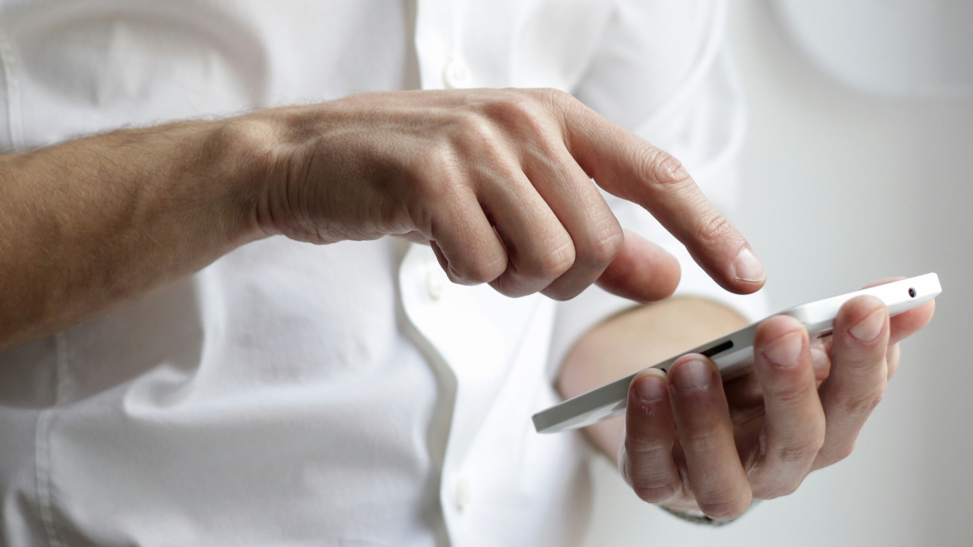 person holding white Android smartphone in white shirt