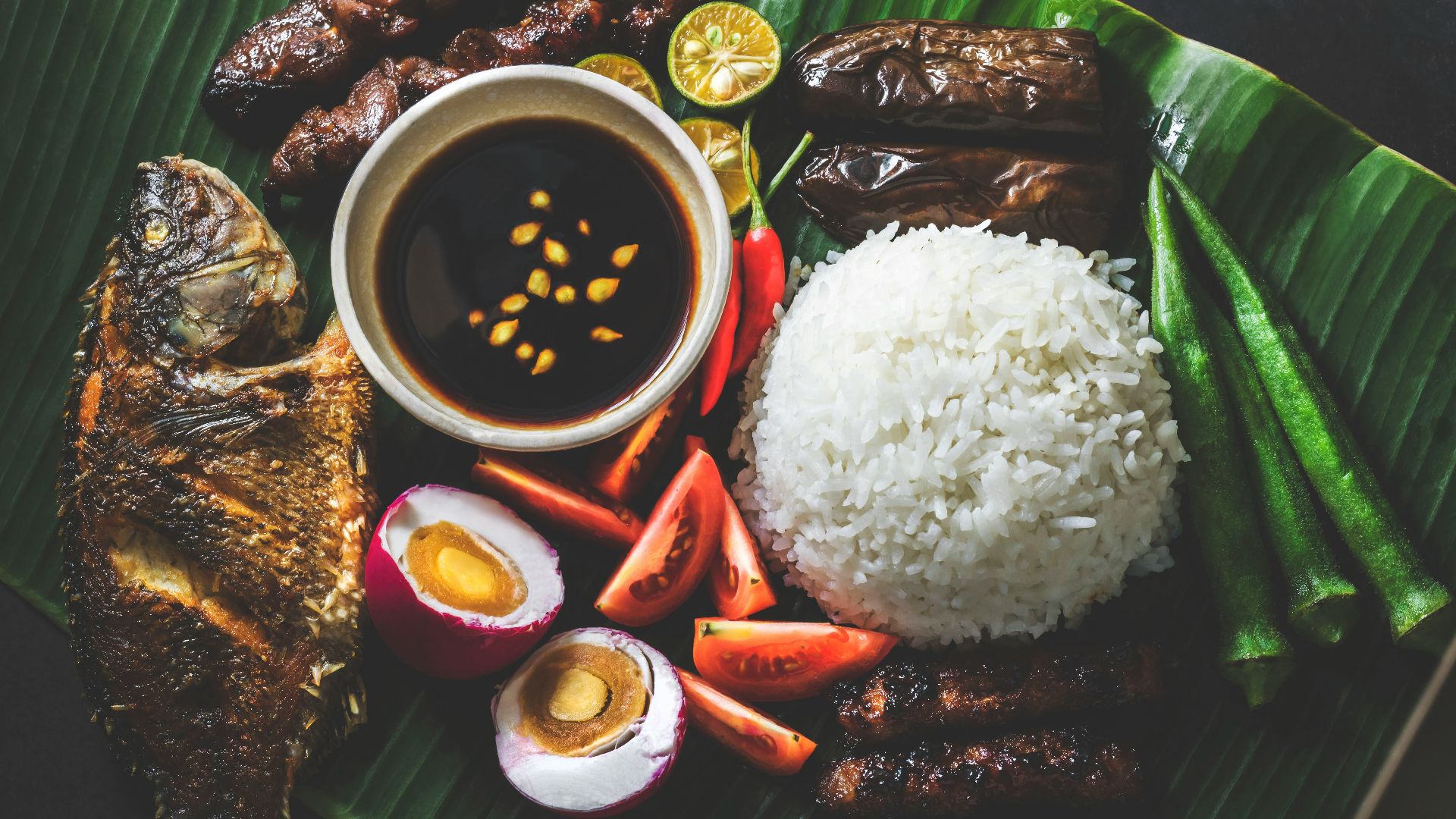 variety of fried dishes on banana leaf