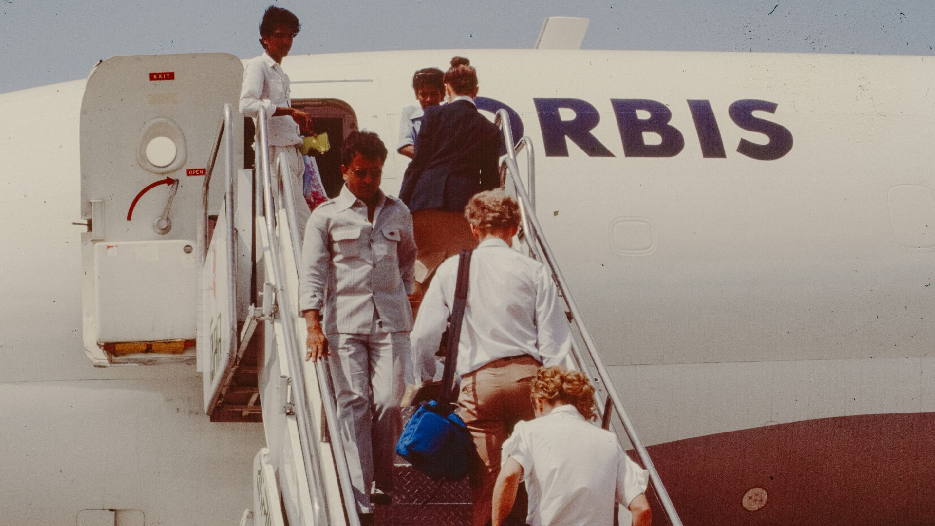 People boarding an airplane on stairs.