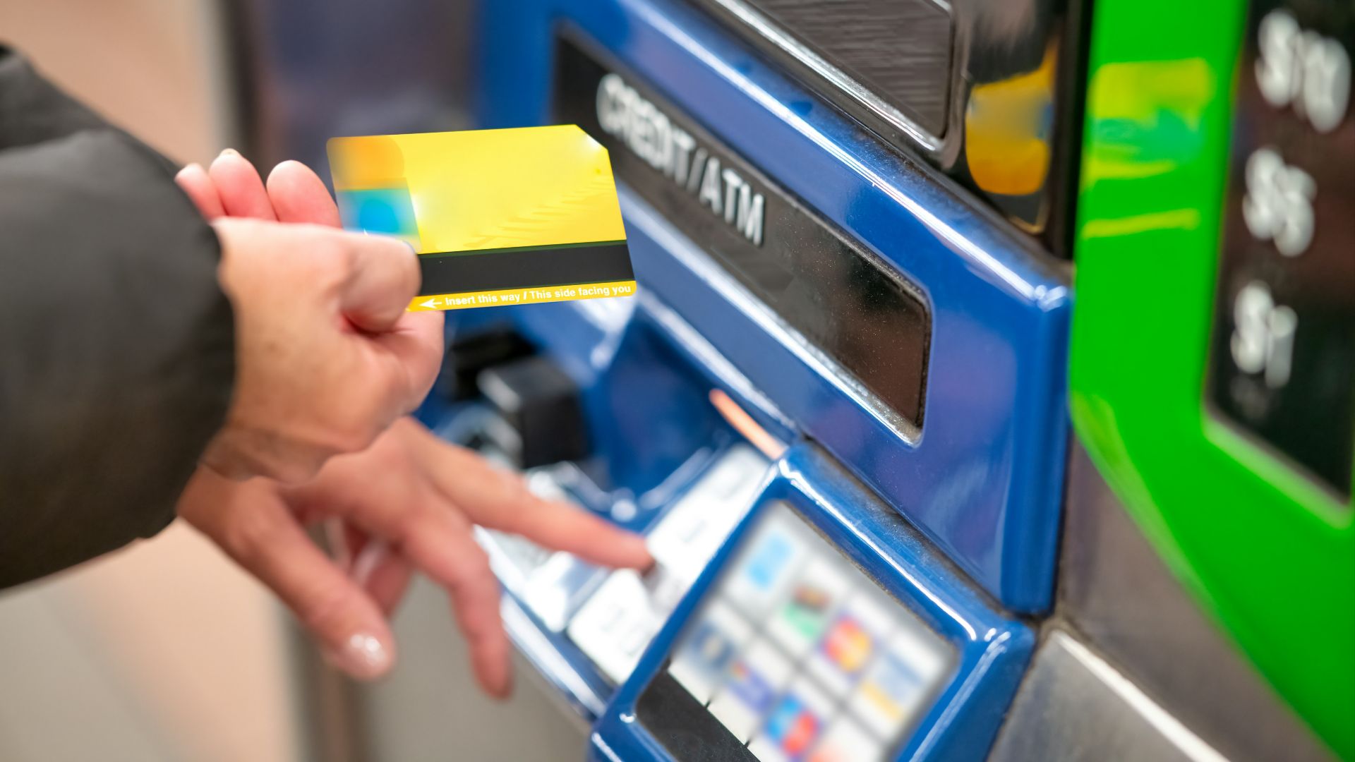 a person using a credit card to pay for a machine