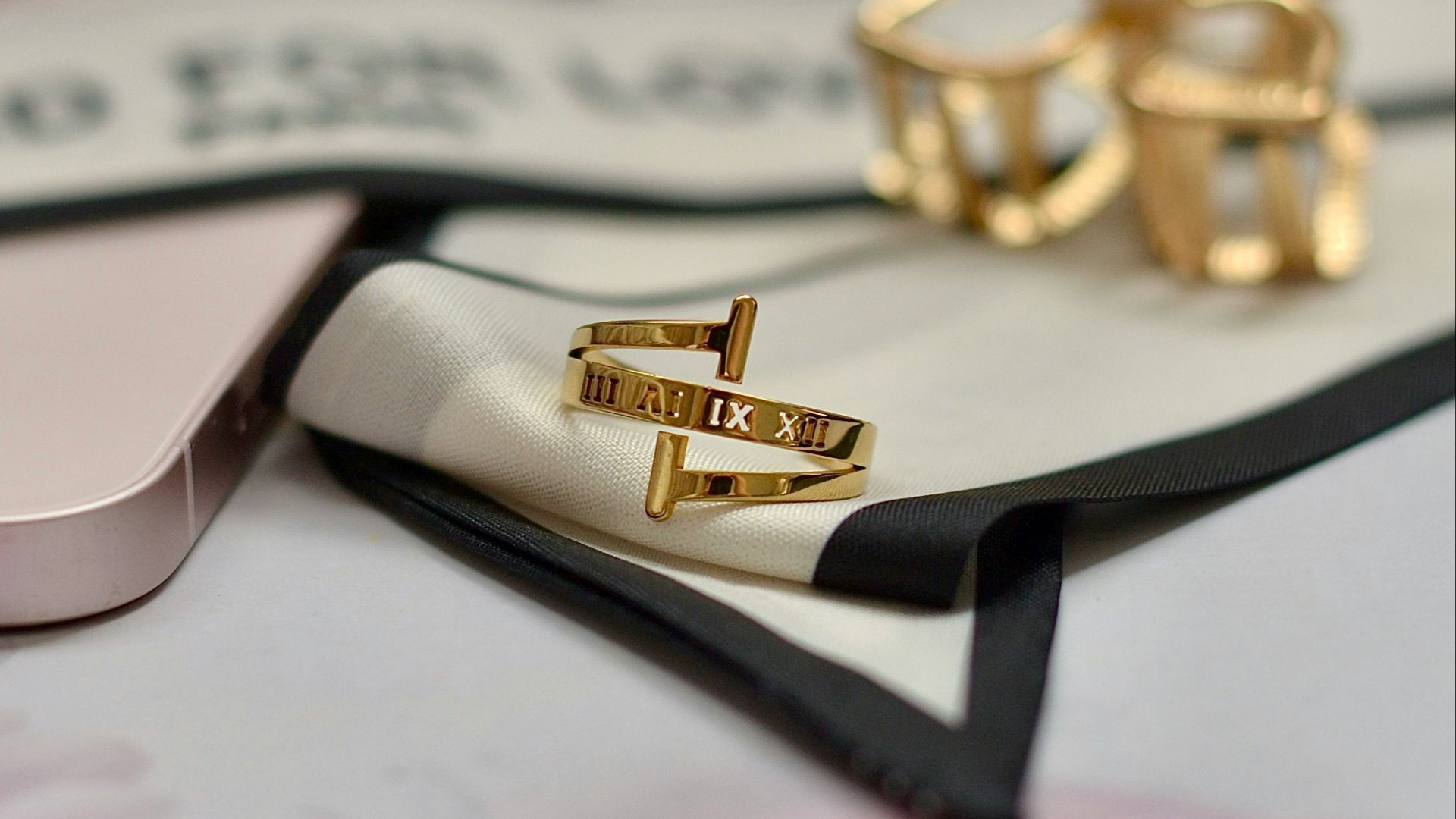 Gold jewelry is resting on a white surface.